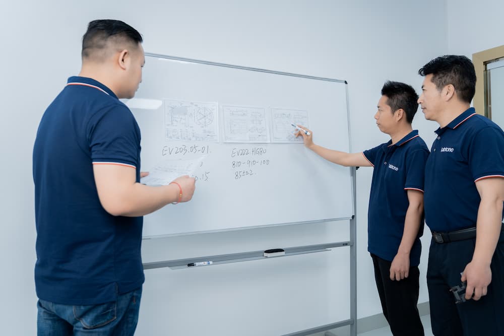 P01 SP05 销售和技术顾问站在白板前讨论设备方案